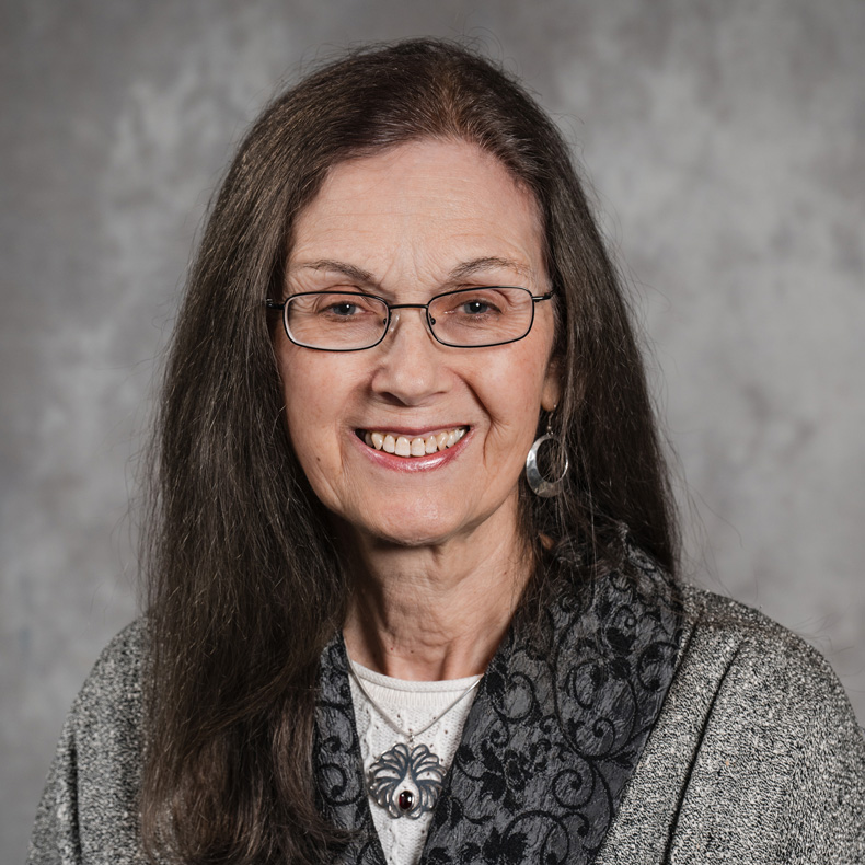 Profile photo of Judy Leavitt in glasses wearing a gray top in a gray background