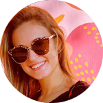 Portrait photo of woman smiling in sunglasses with abstract pink background