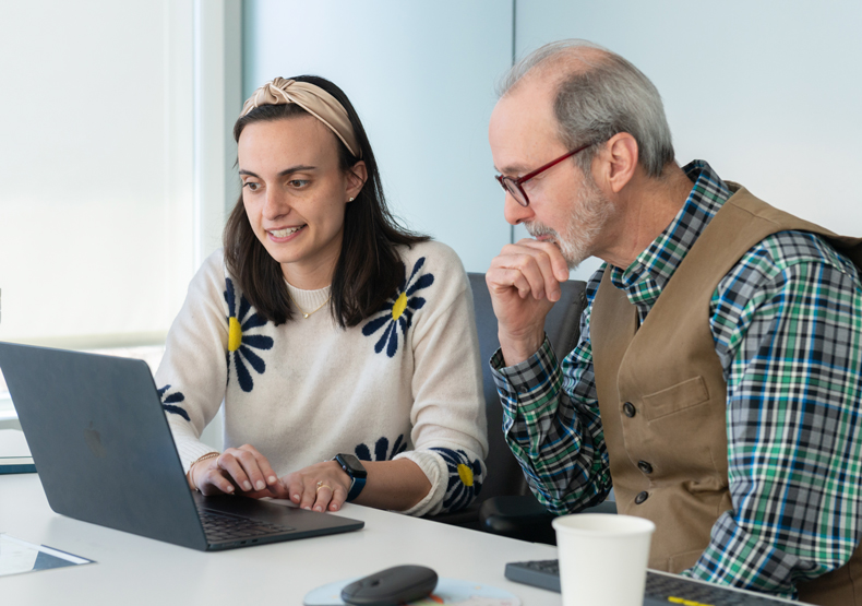 Curriculum man and woman sitting in front of laptop talking