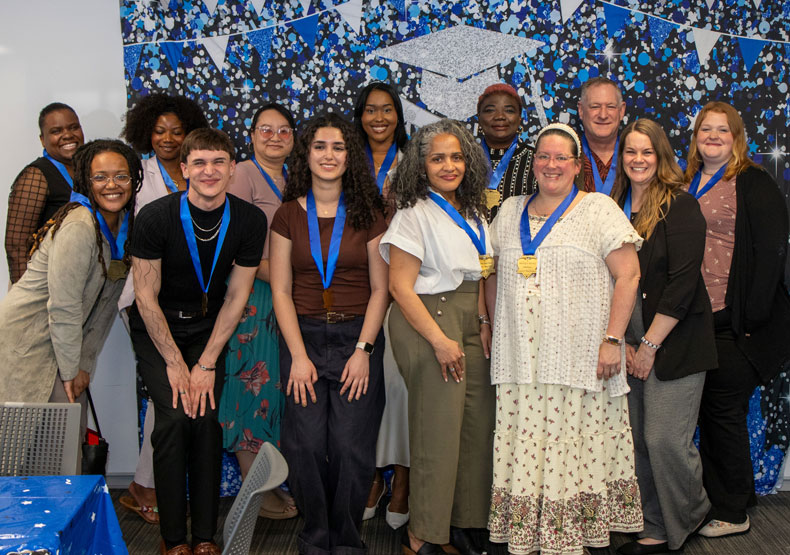 group of young adults in front of decorative blue banner