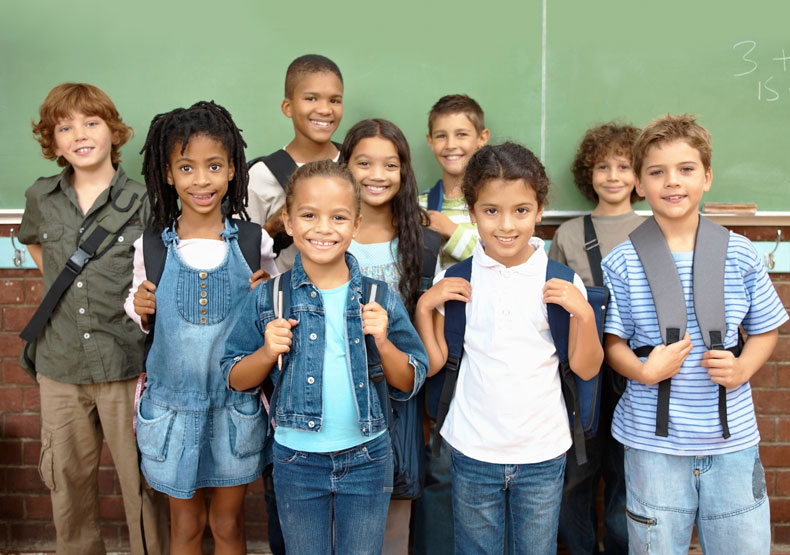 group of young students standing in front of chalkboard