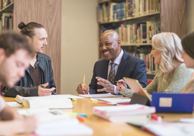 Impact360 Group of adults at a table in a library setting