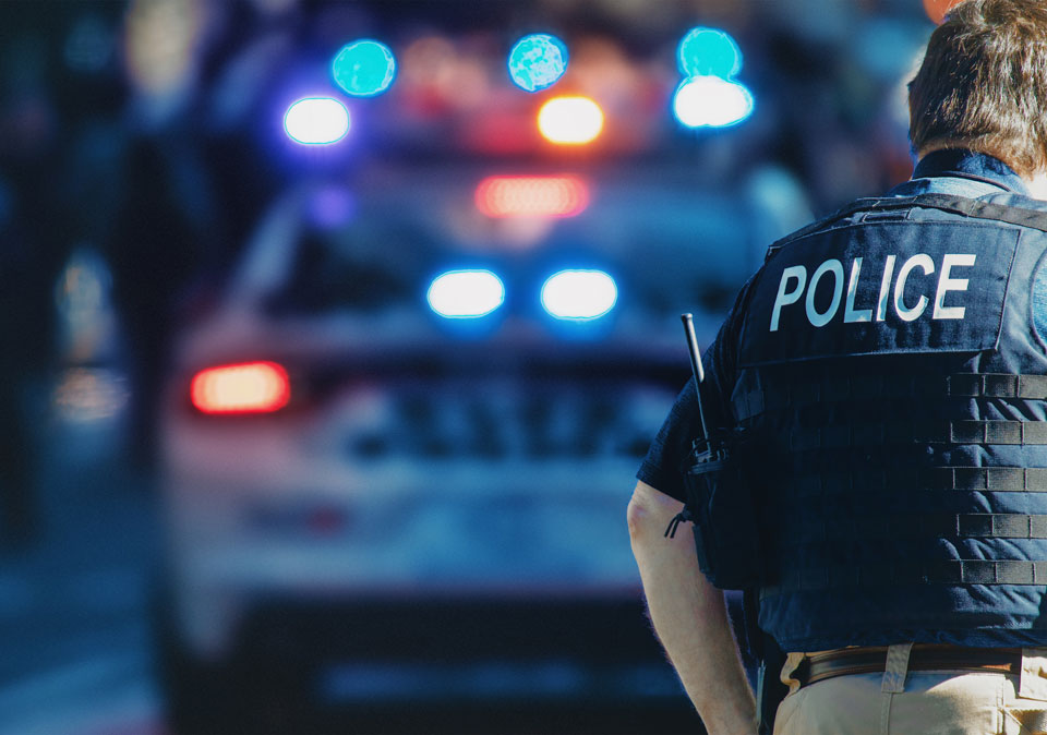 night time scene with back of policeman and car in background