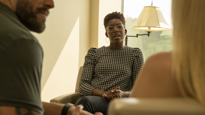 Photo of a female counselor meeting with a man and woman.