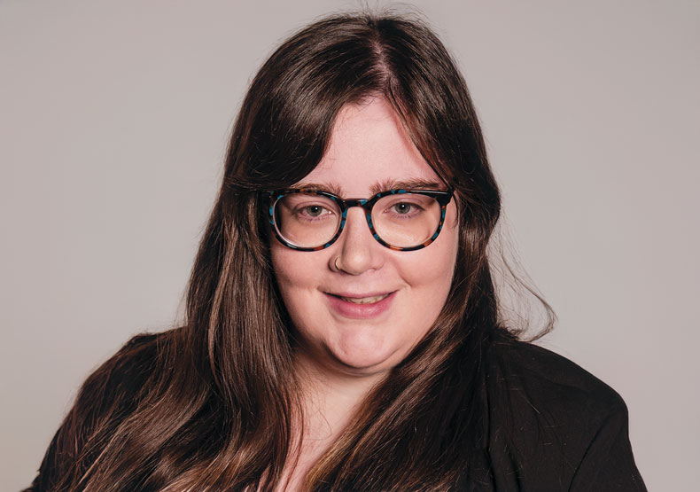 Profile photo of smiling woman with brown hair and glasses