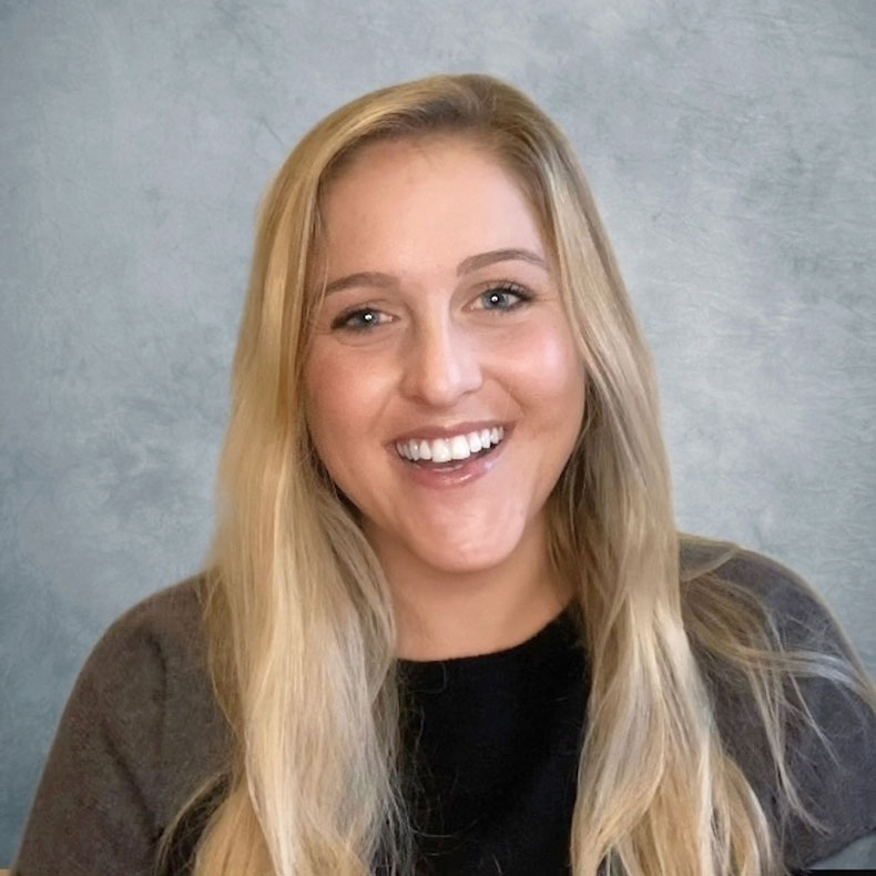 Close up of woman with blonde hair smiling with neutral background