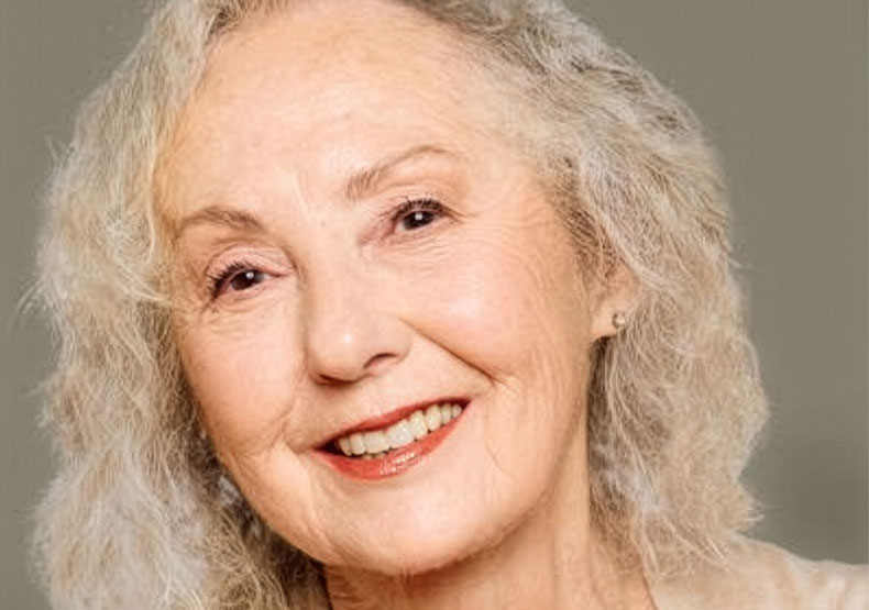 close-up photo of elderly woman smiling with silver blonde hair
