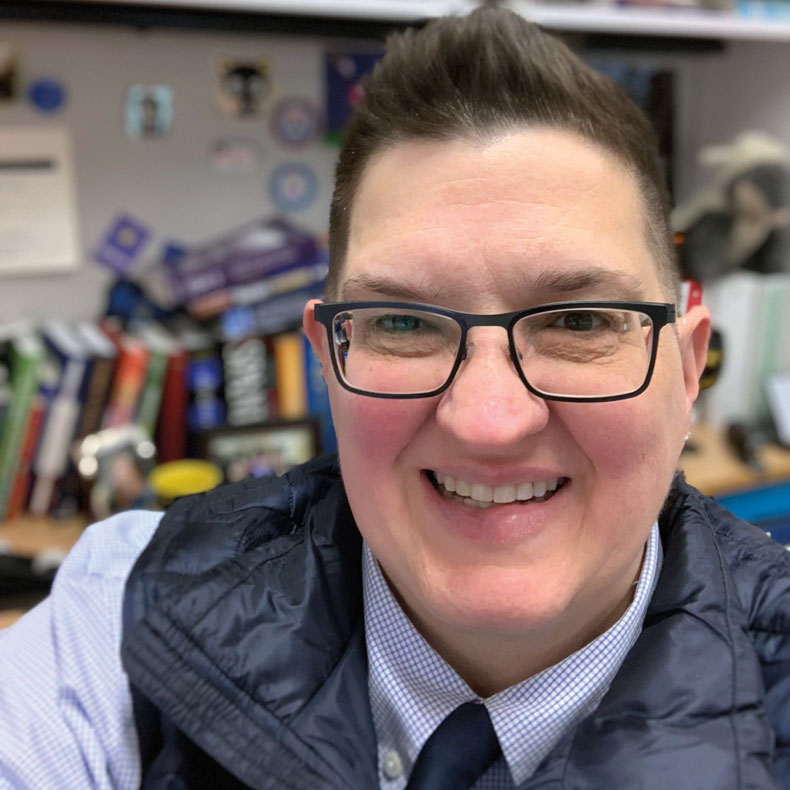 Close-up of person with glasses, and their office in the background