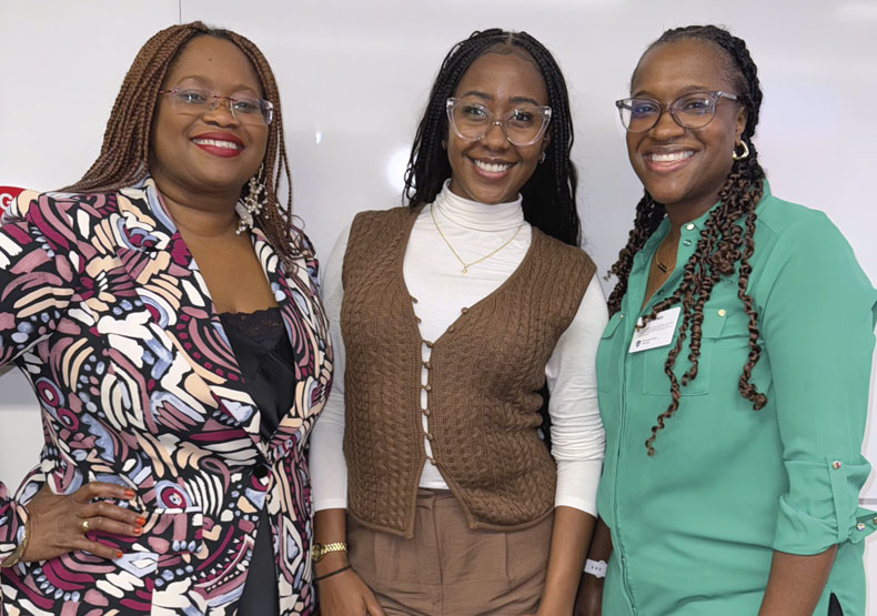 Three Black women standing in front of a white board