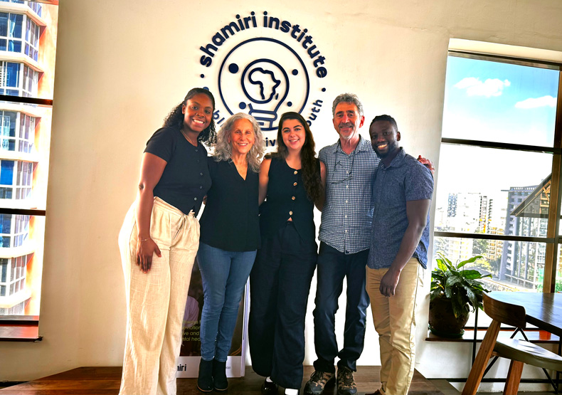 group of people standing in front of a sign