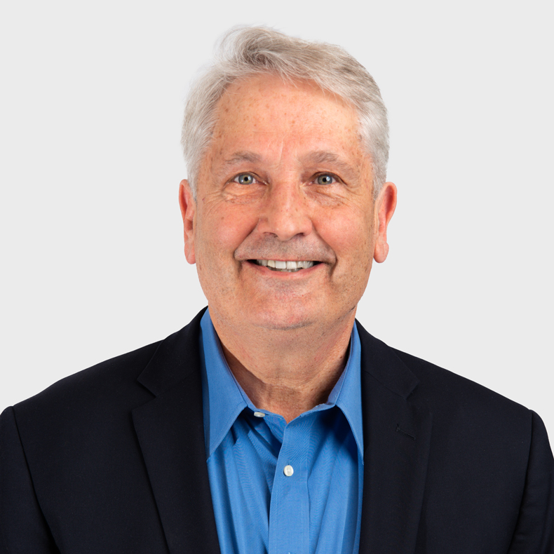 portrait of adult male with white hair and blue shirt