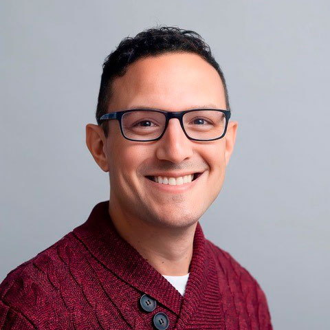 Headshot of man wearing glasses on nuetral background