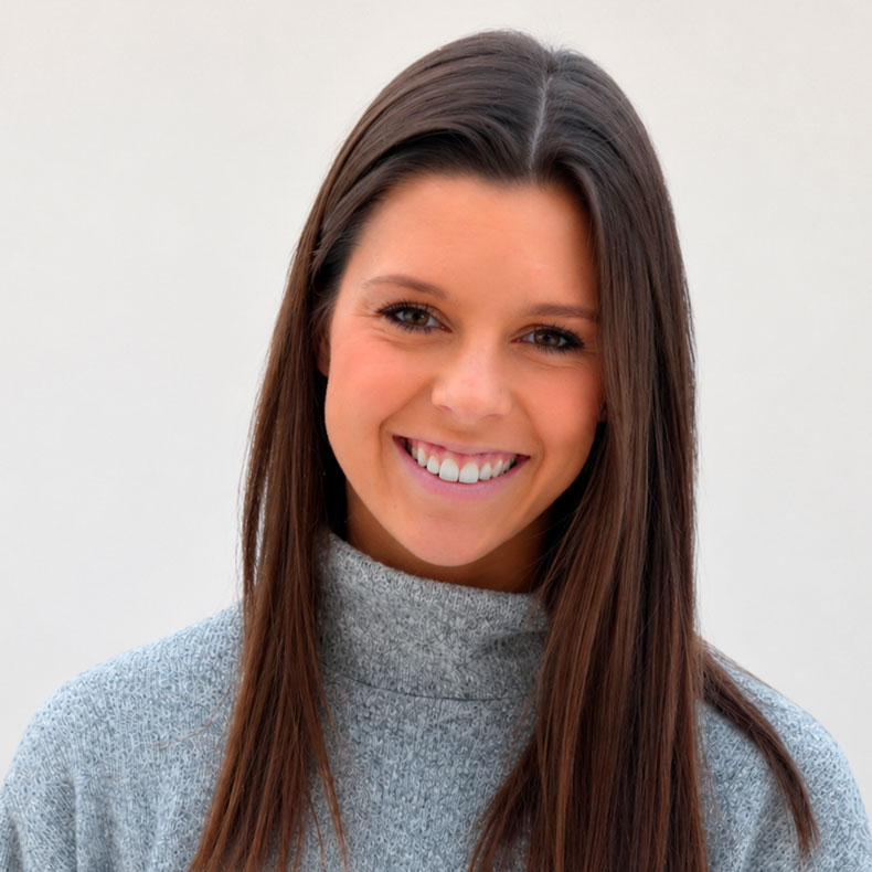 Headshot of smiling white woman with long brown hair on white background