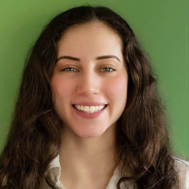 Headshot of woman with long hair and green background